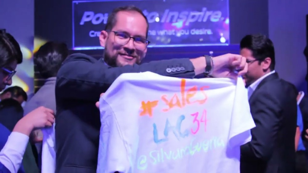 Colaborador recibiendo una playera firmada durante una premiación comercial