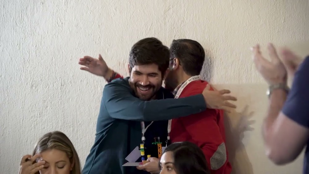 Abrazo y aplausos entre compañeros al cierre de una activación interna
